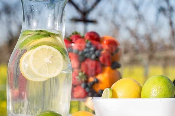 low fodmap foods pitcher of water with low fodmap gluten free lime and low fodmap gluten free berries