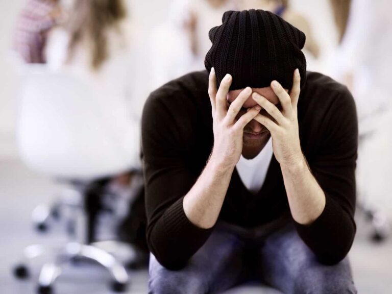 person holding head with headache vitamin A toxicity on gluten free diet