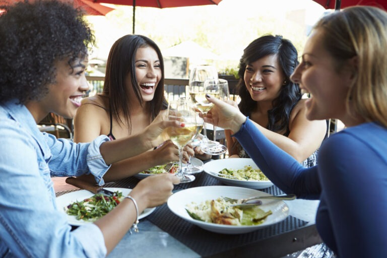 Reasons for gluten free diet- people sitting at restaurant smiling and laughing