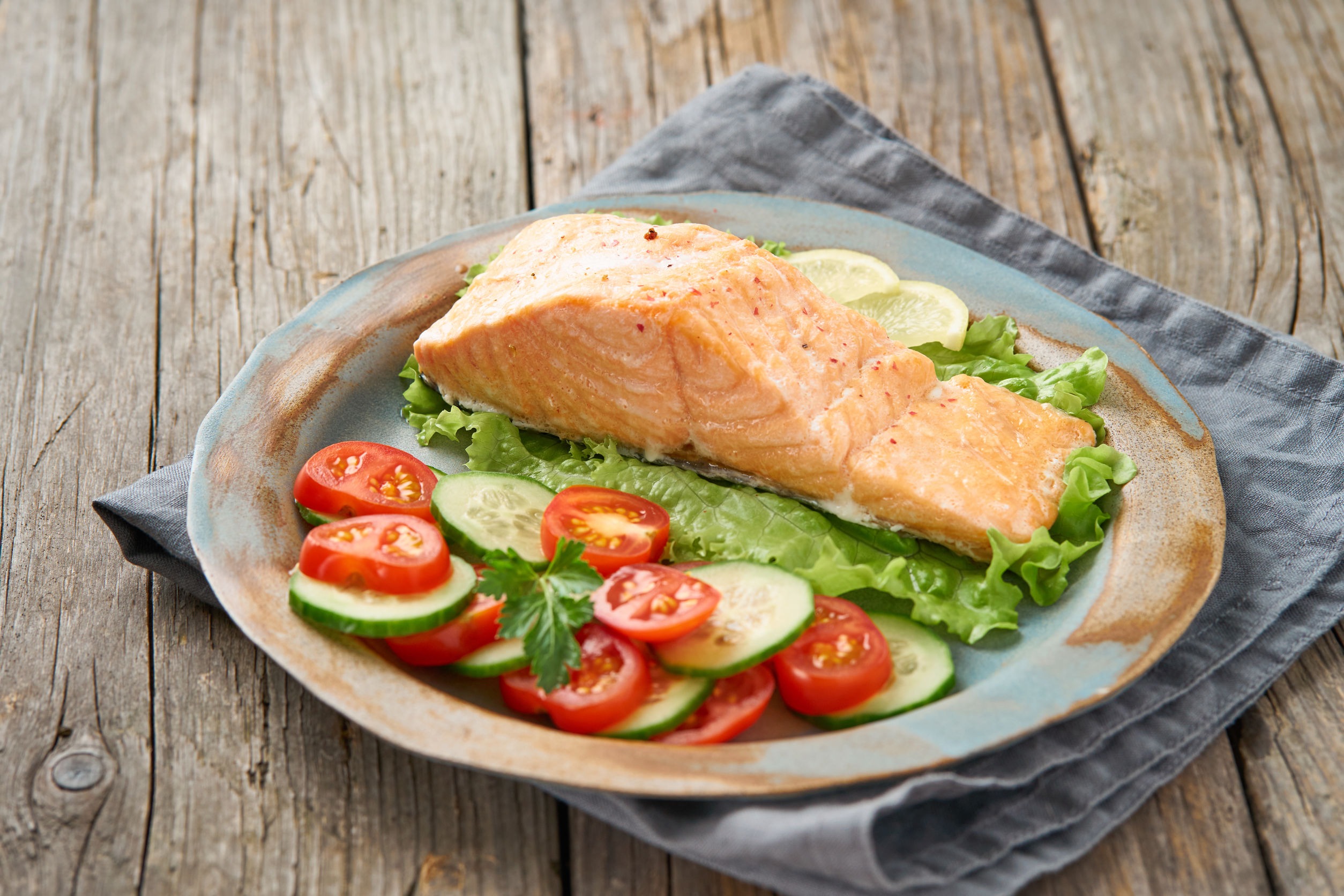 Salmon on a plate with tomatoes and cucumber. All are ok on a low fodmap and gluten free diet