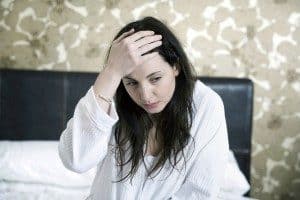 pots syndrome can cause headaches and flu-like symptoms. image is of a woman holding her head