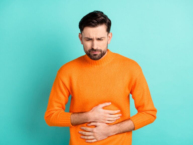 Man with beard in orange shirt-he has SIBO and is looking unwell. His sibo symptoms need a sibo test and sibo treatment