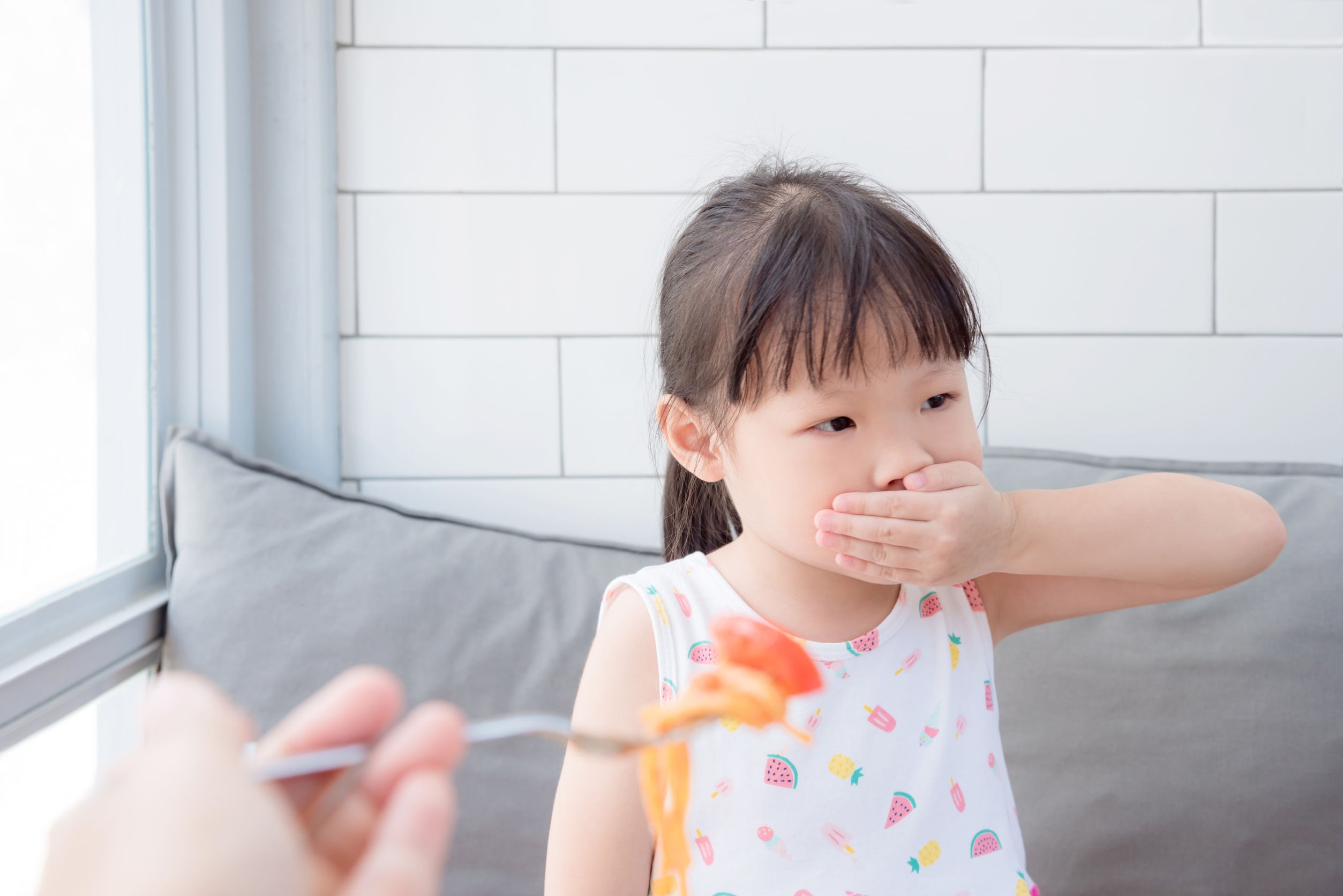 What is ARFID? More than a picky eater. This little girl is covering her mouth while a spoon of food is coming closer to her