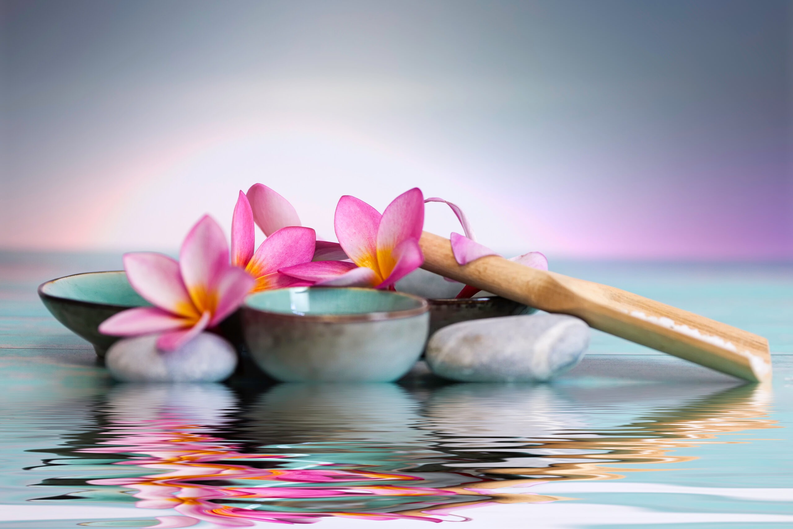 frangipani flowers as a spa concept with zen stones and small bowls.