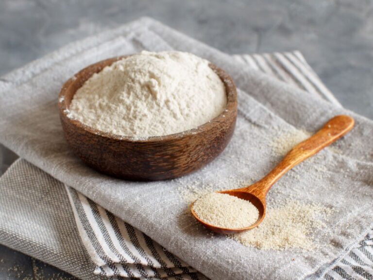 Fonio flour and a spoon with fonio grain all sitting on a linen napkin