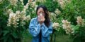 histamine intolerance symptoms in clude sneezing like the woman in the photo surrounded by flowers