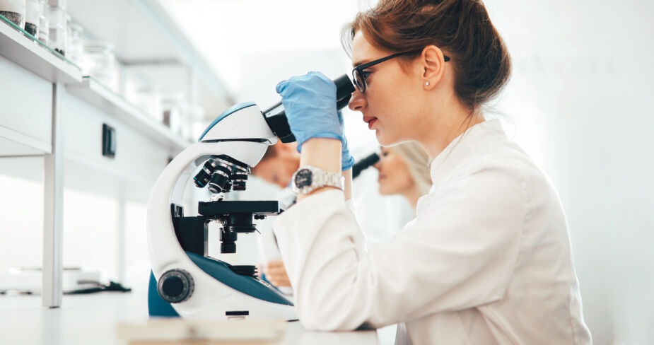scientist looking at microscope results of a biopsy